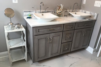 Diseño de cuarto de baño gris y blanco contemporáneo de tamaño medio con armarios estilo shaker, puertas de armario grises, paredes grises, suelo de mármol, aseo y ducha, lavabo sobreencimera y encimera de mármol