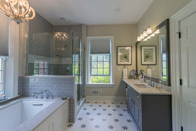 Inspiration for a mid-sized transitional master gray tile and subway tile ceramic tile and white floor corner shower remodel in Other with an undermount tub, a two-piece toilet, an undermount sink, a hinged shower door, raised-panel cabinets, gray cabinets, beige walls and marble countertops