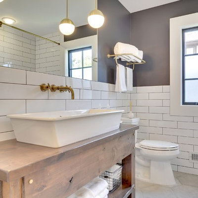 Inspiration for a transitional white tile gray floor bathroom remodel in Minneapolis with furniture-like cabinets, medium tone wood cabinets, gray walls, a vessel sink, wood countertops and brown countertops