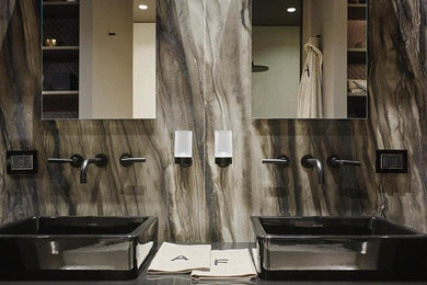 Diseño de cuarto de baño principal minimalista con baldosas y/o azulejos marrones, losas de piedra, lavabo sobreencimera, encimera de acero inoxidable y encimeras grises