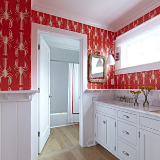 Design ideas for a large beach style kids bathroom in New York with shaker cabinets, white cabinets, a freestanding tub, a shower/bathtub combo, a two-piece toilet, red walls, light hardwood floors, an undermount sink and marble benchtops.