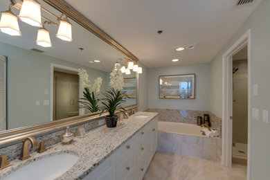 Example of a mid-sized transitional master beige tile, brown tile and stone slab ceramic tile and beige floor bathroom design in Tampa with shaker cabinets, white cabinets, a two-piece toilet, blue walls, an undermount sink, terrazzo countertops and a hinged shower door