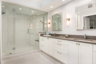 Inspiration for a large transitional master porcelain tile and beige floor double shower remodel in Miami with recessed-panel cabinets, white cabinets, white walls, an undermount sink, granite countertops and a hinged shower door