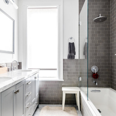Inspiration for a transitional gray tile and subway tile drop-in bathtub remodel in New York with shaker cabinets, gray cabinets, white walls and an undermount sink