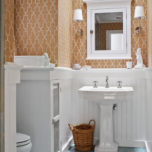 Inspiration for a beach style bathroom in New York with a pedestal sink, an alcove shower, a two-piece toilet, orange walls, painted wood floors and turquoise floor.