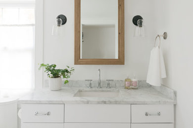 Small beach style master bathroom photo in Other with shaker cabinets, marble countertops and a hinged shower door