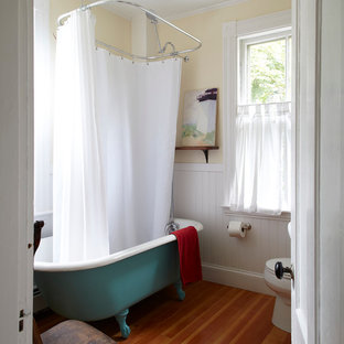 Beach style claw-foot bathtub photo in San Francisco with yellow walls