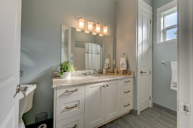 Small transitional 3/4 gray tile and ceramic tile ceramic tile bathroom photo in Vancouver with shaker cabinets, white cabinets, a one-piece toilet, gray walls, an undermount sink and quartz countertops