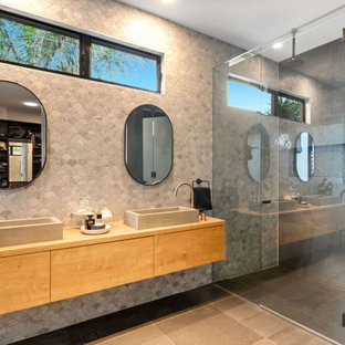 Contemporary bathroom in Sunshine Coast with flat-panel cabinets, medium wood cabinets, gray tile, a vessel sink, wood benchtops, grey floor, brown benchtops and a double vanity.