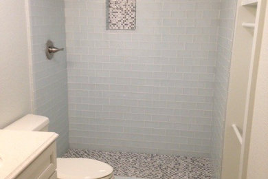 Double shower - small tropical 3/4 white tile and glass tile porcelain tile double shower idea in Sacramento with recessed-panel cabinets, white cabinets, quartz countertops, a one-piece toilet, an undermount sink and beige walls