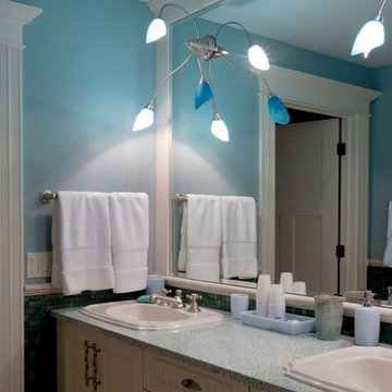 Beadboard bathroom cabinetry with dual sinks and contemporary lighting