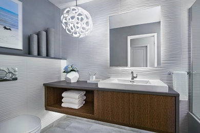 Bathroom - small modern 3/4 white tile and porcelain tile marble floor and gray floor bathroom idea in Detroit with flat-panel cabinets, brown cabinets, a wall-mount toilet, white walls, a vessel sink, concrete countertops, a hinged shower door and gray countertops