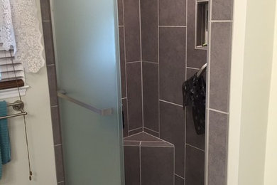 Diseño de cuarto de baño tradicional renovado de tamaño medio con armarios con paneles con relieve, puertas de armario de madera oscura, baldosas y/o azulejos multicolor y encimera de cuarzo compacto