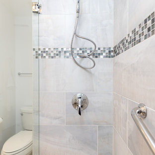 This is an example of a mid-sized transitional 3/4 bathroom in DC Metro with shaker cabinets, white cabinets, an alcove shower, a two-piece toilet, gray tile, white tile, porcelain tile, white walls, travertine floors, an undermount sink and quartzite benchtops.