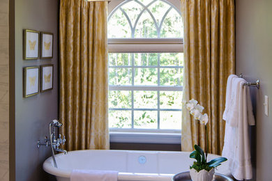 Imagen de cuarto de baño tradicional de tamaño medio con bañera exenta, paredes grises, suelo de mármol y aseo y ducha