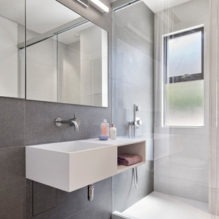 Bathroom - small contemporary kids' gray tile gray floor and single-sink bathroom idea in San Francisco with open cabinets, white cabinets, a wall-mount toilet, an integrated sink, white countertops and a floating vanity