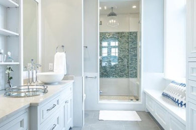 Example of a mid-sized transitional master blue tile, green tile and mosaic tile medium tone wood floor and brown floor alcove shower design in New York with shaker cabinets, white cabinets, beige walls, a vessel sink, quartz countertops and a hinged shower door