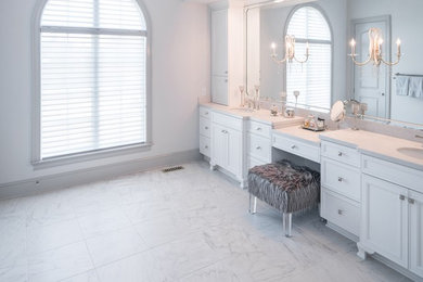 Foto de cuarto de baño principal clásico renovado grande con armarios con rebordes decorativos, puertas de armario blancas, paredes blancas, suelo de mármol, lavabo bajoencimera, encimera de mármol y suelo gris