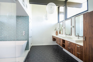 Huge trendy master blue tile black floor and double-sink bathroom photo in Los Angeles with flat-panel cabinets, medium tone wood cabinets, white walls, a vessel sink, white countertops and a floating vanity