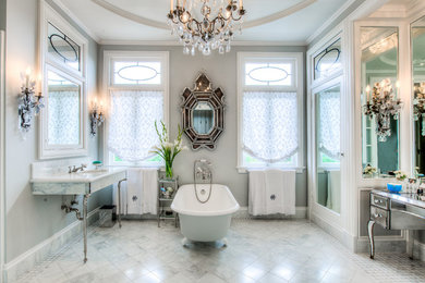 Immagine di una stanza da bagno classica con vasca con piedi a zampa di leone e lavabo a consolle