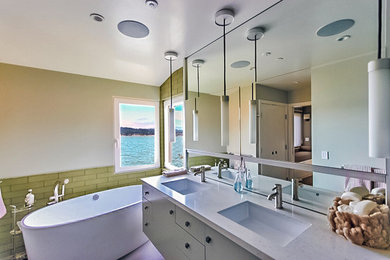 Medium sized modern ensuite bathroom in San Francisco with flat-panel cabinets, green cabinets, a freestanding bath, green tiles, a submerged sink, green walls and ceramic flooring.