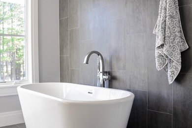 Freestanding bathtub - modern master freestanding bathtub idea in New York with tile countertops