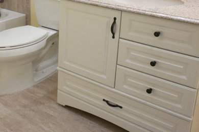 デンバーにある低価格の小さなトラディショナルスタイルのおしゃれなバスルーム (浴槽なし) (レイズドパネル扉のキャビネット、白いキャビネット、アルコーブ型浴槽、シャワー付き浴槽	、分離型トイレ、黄色い壁、ラミネートの床、アンダーカウンター洗面器、御影石の洗面台、ベージュの床、シャワーカーテン) の写真