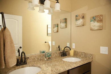 Bathroom photo in Grand Rapids with an undermount sink, flat-panel cabinets, dark wood cabinets, granite countertops and beige walls