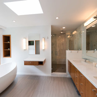 Ispirazione per una grande stanza da bagno padronale moderna con vasca freestanding, ante lisce, ante in legno bruno, doccia alcova, piastrelle grigie, piastrelle di marmo, pareti bianche, pavimento in gres porcellanato, lavabo sottopiano, top in marmo, pavimento marrone, porta doccia a battente e top bianco