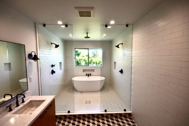 Example of a large minimalist master white tile and porcelain tile porcelain tile and multicolored floor bathroom design in Los Angeles with flat-panel cabinets, medium tone wood cabinets, a two-piece toilet, white walls, an undermount sink, quartz countertops and white countertops