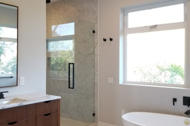 Large minimalist master marble floor and white floor alcove shower photo in Los Angeles with flat-panel cabinets, dark wood cabinets, quartz countertops, a hinged shower door and white countertops