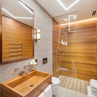Design ideas for a large world-inspired ensuite bathroom in London with flat-panel cabinets, white cabinets, a walk-in shower, a wall mounted toilet, marble tiles, a wall-mounted sink, wooden worktops, an open shower and beige walls.