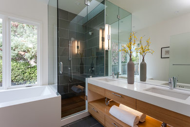 Example of a mid-sized trendy master gray tile slate floor corner shower design in San Francisco with an undermount sink, flat-panel cabinets, light wood cabinets, quartz countertops, a one-piece toilet, white walls and an undermount tub