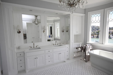 Example of a transitional bathroom design in San Francisco with flat-panel cabinets, white cabinets and marble countertops