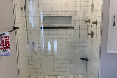 Alcove shower - small transitional white tile and subway tile porcelain tile and gray floor alcove shower idea in Other with gray walls and a hinged shower door