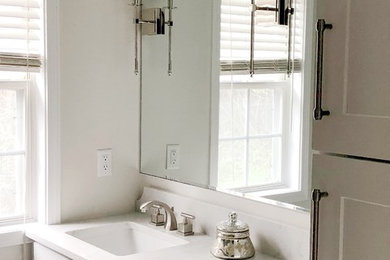 Mid-sized transitional master porcelain tile porcelain tile bathroom photo in Atlanta with shaker cabinets, white cabinets, a one-piece toilet, a drop-in sink, solid surface countertops, a hinged shower door and white countertops