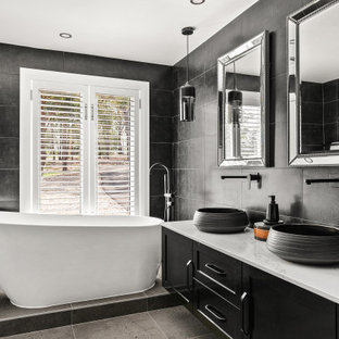 Design ideas for a large contemporary master bathroom in Sydney with black cabinets, a freestanding tub, gray tile, grey walls, ceramic floors, granite benchtops, white benchtops, a floating vanity, shaker cabinets, a vessel sink, grey floor and a double vanity.