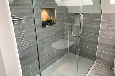 Photo of a large modern shower room bathroom in Surrey with grey tiles, glass-front cabinets and grey cabinets.