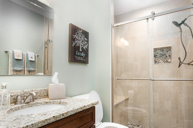 Bathroom - mid-sized traditional 3/4 beige tile and porcelain tile travertine floor and beige floor bathroom idea in Chicago with raised-panel cabinets, dark wood cabinets, a two-piece toilet, gray walls, an undermount sink, granite countertops and beige countertops