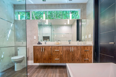 Large minimalist master white tile and porcelain tile porcelain tile and brown floor bathroom photo in Los Angeles with flat-panel cabinets, medium tone wood cabinets, a two-piece toilet, white walls, an undermount sink, a hinged shower door and solid surface countertops