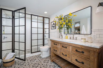 Double shower - large traditional master white tile and subway tile ceramic tile and multicolored floor double shower idea in Los Angeles with furniture-like cabinets, medium tone wood cabinets, white walls, an undermount sink, a hinged shower door, a two-piece toilet and marble countertops