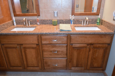 Bathroom - mid-sized traditional master beige tile bathroom idea in Boston with an undermount sink, raised-panel cabinets, medium tone wood cabinets, quartz countertops and beige walls