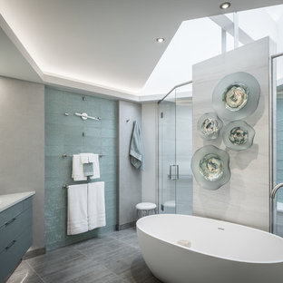 Ispirazione per una stanza da bagno padronale design con vasca freestanding, doccia doppia, piastrelle verdi, piastrelle di vetro, pareti grigie, lavabo sottopiano, top in quarzo composito, pavimento grigio, porta doccia a battente, ante lisce, ante verdi e pavimento in gres porcellanato
