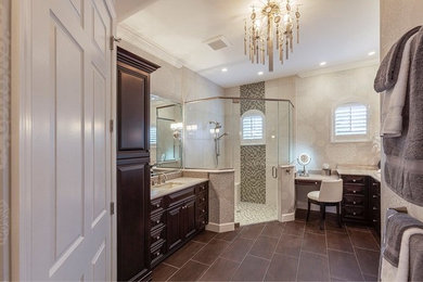 Large classic ensuite bathroom in Tampa with raised-panel cabinets, dark wood cabinets, a corner shower, beige tiles, grey tiles, mosaic tiles, beige walls, porcelain flooring, a submerged sink, brown floors and a hinged door.