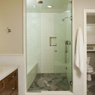 Immagine di una stanza da bagno boho chic con ante in stile shaker, ante in legno bruno, doccia alcova e piastrelle in pietra