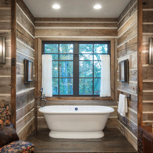 Imagen de cuarto de baño principal, rural, con bañera exenta, paredes marrones, suelo de madera oscura y suelo marrón
