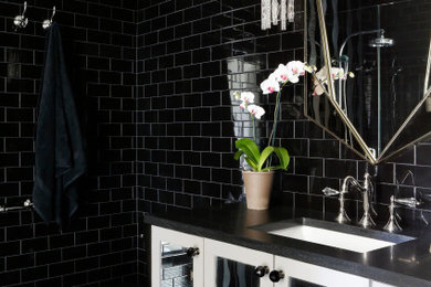Photo of a medium sized classic family bathroom in Nashville with glass-front cabinets, white cabinets, a corner shower, a one-piece toilet, black tiles, metro tiles, black walls, porcelain flooring, a submerged sink, engineered stone worktops, black floors, an open shower and black worktops.