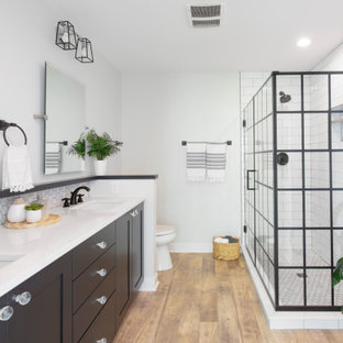 Inspiration för ett mellanstort funkis vit vitt en-suite badrum, med svarta skåp, en hörndusch, en toalettstol med separat cisternkåpa, vit kakel, tunnelbanekakel, vinylgolv, ett undermonterad handfat, bänkskiva i kvarts, brunt golv, dusch med gångjärnsdörr, grå väggar och skåp i shakerstil