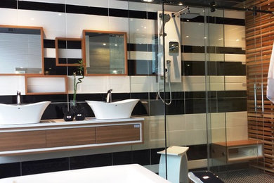 Inspiration for a medium sized modern ensuite bathroom in Toronto with a vessel sink, flat-panel cabinets, brown cabinets, quartz worktops, a freestanding bath, a one-piece toilet, porcelain tiles, mosaic tile flooring, multi-coloured tiles, multi-coloured walls and blue floors.