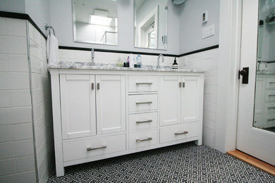 Inspiration for a mid-sized transitional master white tile and ceramic tile cement tile floor and black floor bathroom remodel in Montreal with shaker cabinets, white cabinets, a one-piece toilet, gray walls, an undermount sink, marble countertops, a hinged shower door and gray countertops